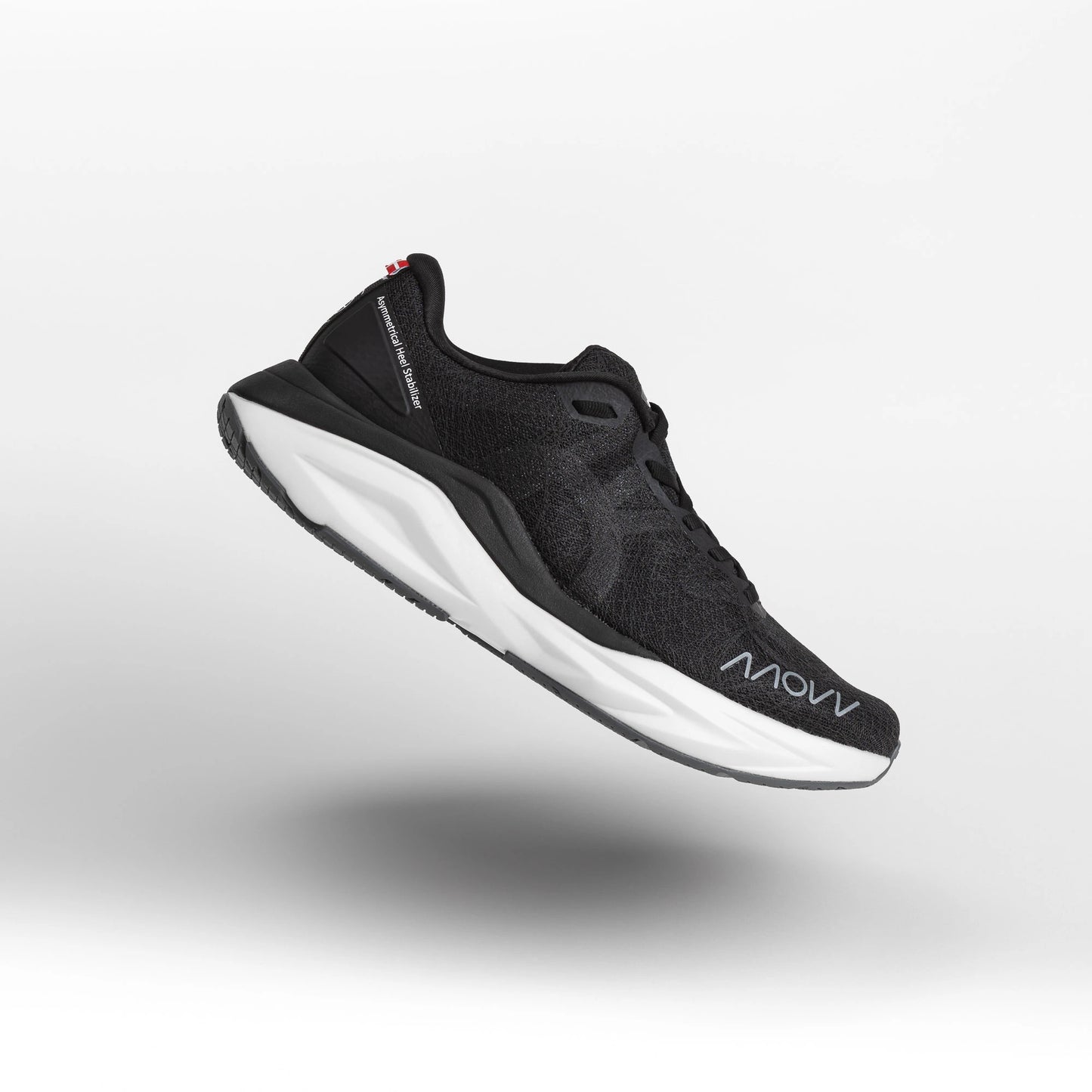 A black athletic running shoe with white midsole photographed against a light gray background. The shoe features a dark mesh upper material, black laces, and MOVV branding visible on the side.