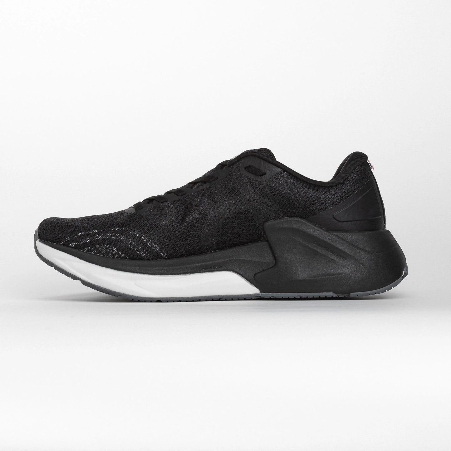 Inner side view of a black MOVV running shoe with a streamlined design, cushioned white midsole, and reinforced black heel structure for stability.