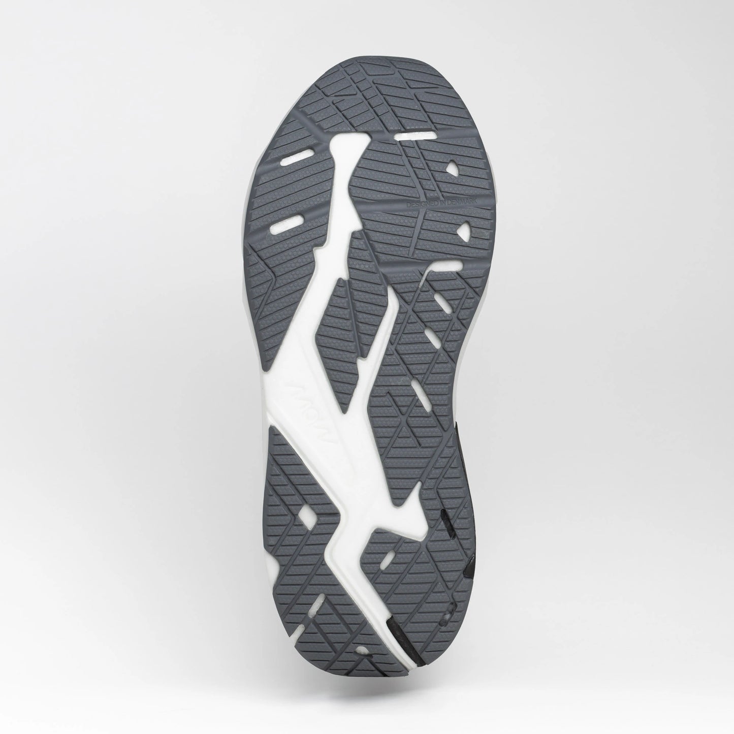 Close-up view of the grey and white rubber outsole of a running shoe, showing its textured tread pattern for grip and flexibility.