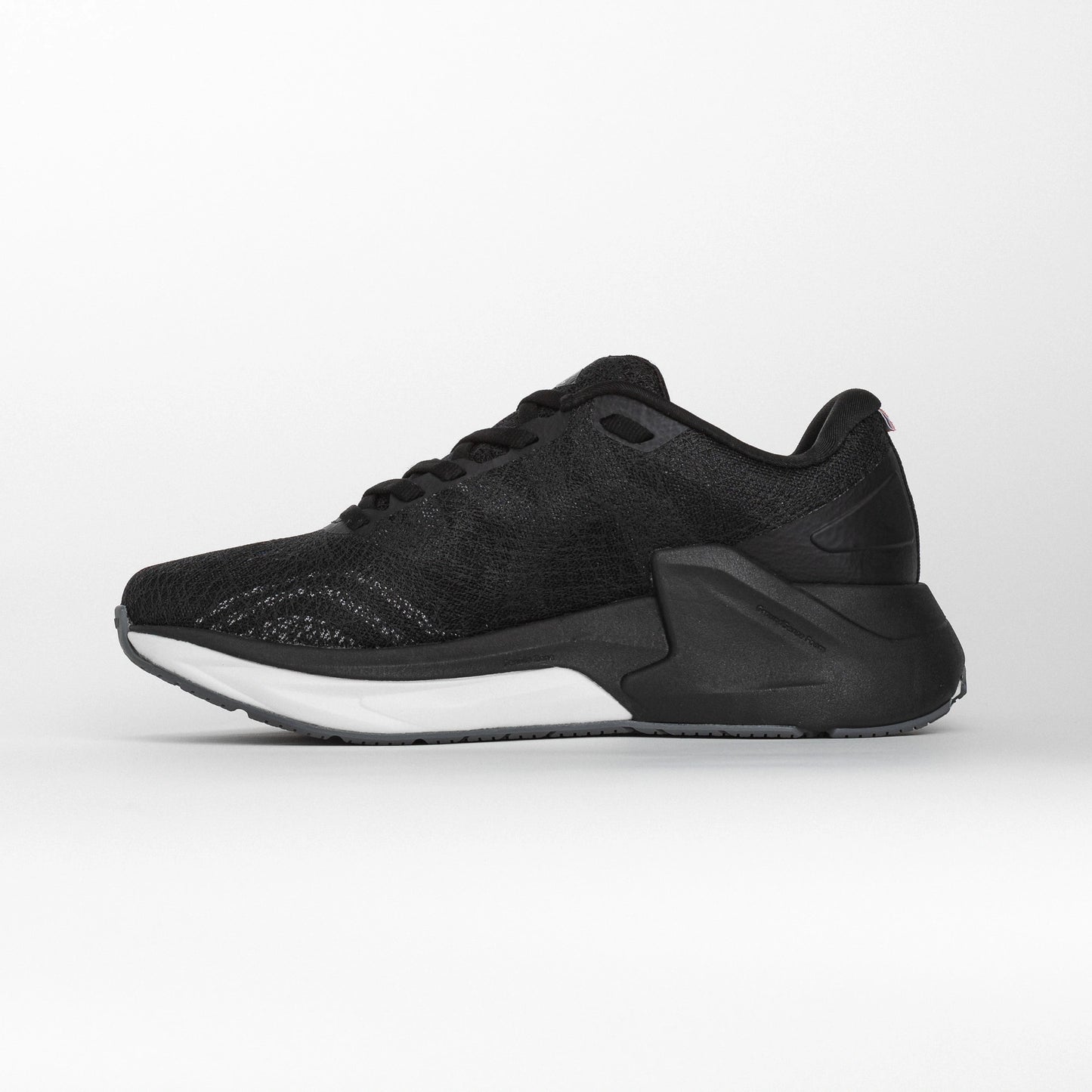 Inner side view of a black MOVV running shoe with a streamlined design, cushioned white midsole, and reinforced black heel structure for stability.