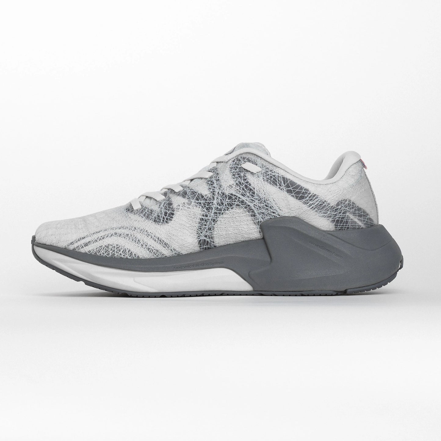 Inner side view of a white and grey MOVV running shoe with a streamlined design, cushioned grey midsole, and reinforced heel structure for stability.