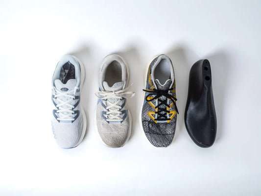 Minimalistic white and grey running shoe designed for injury reduction on white background