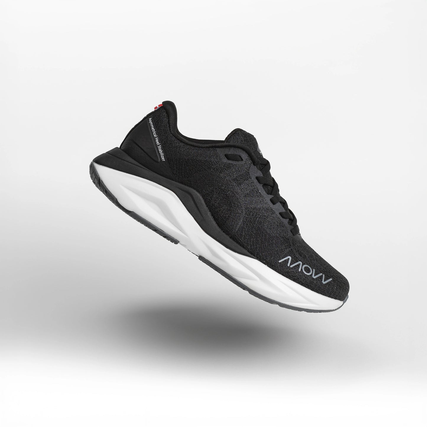 A black athletic running shoe with white midsole photographed against a light gray background. The shoe features a dark mesh upper material, black laces, and MOVV branding visible on the side.