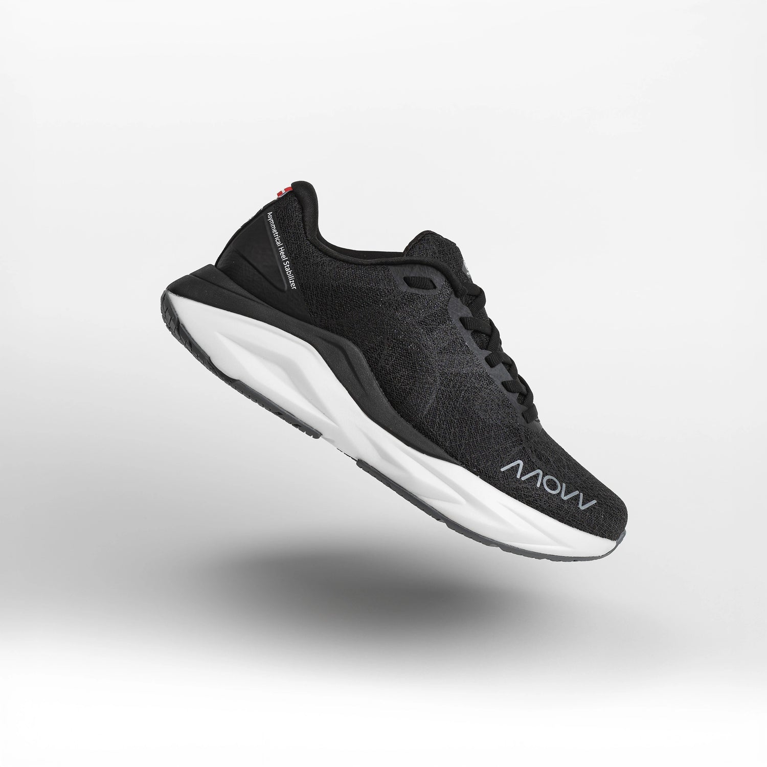 A black athletic running shoe with white midsole photographed against a light gray background. The shoe features a dark mesh upper material, black laces, and MOVV branding visible on the side.