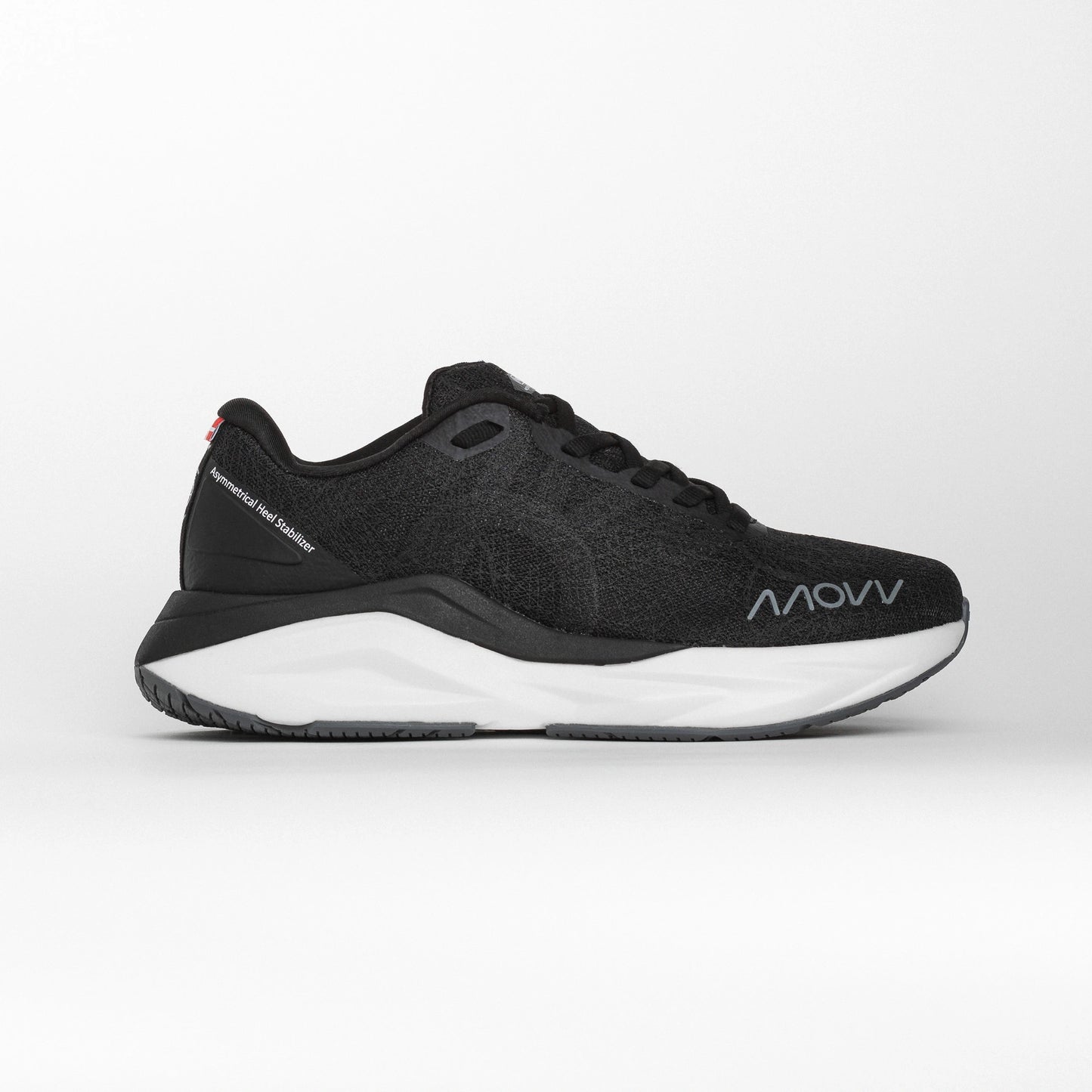 Side profile of a black MOVV running shoe with a white midsole and grey outsole, featuring the brand logo near the toe and an asymmetric heel stabilizer for support.