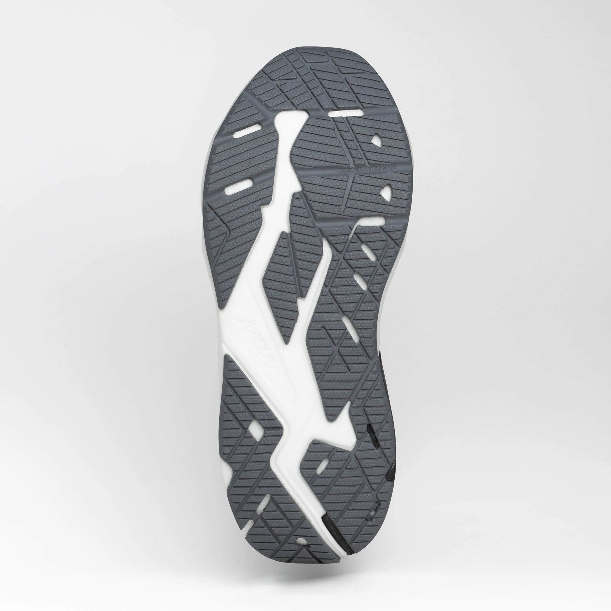 Close-up view of the grey and white rubber outsole of a running shoe, showing its textured tread pattern for grip and flexibility.